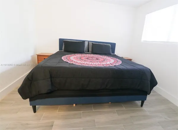 a bed sitting in a bedroom next to a window