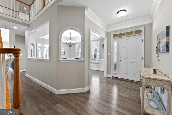 a view of a hallway with wooden floor and a living room