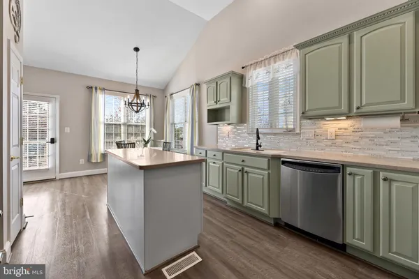 a kitchen with a sink cabinets and wooden floor
