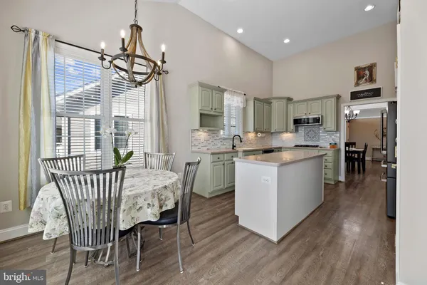 a kitchen with kitchen island white cabinets and refrigerator