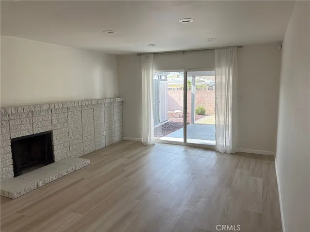 an empty room with wooden floor and fireplace