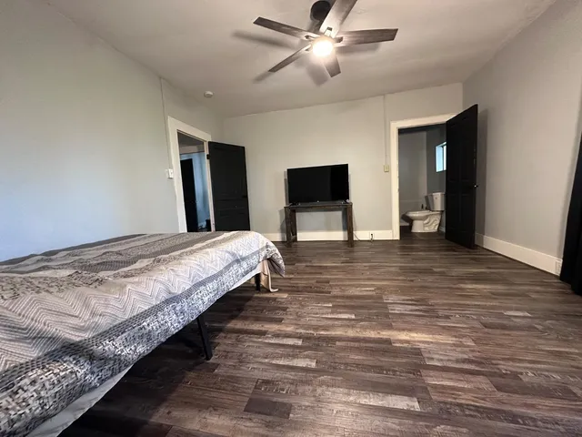 a spacious bedroom with a bed and a chandelier