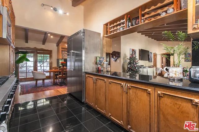 a kitchen with stainless steel appliances kitchen island granite countertop a stove a refrigerator and wooden cabinets