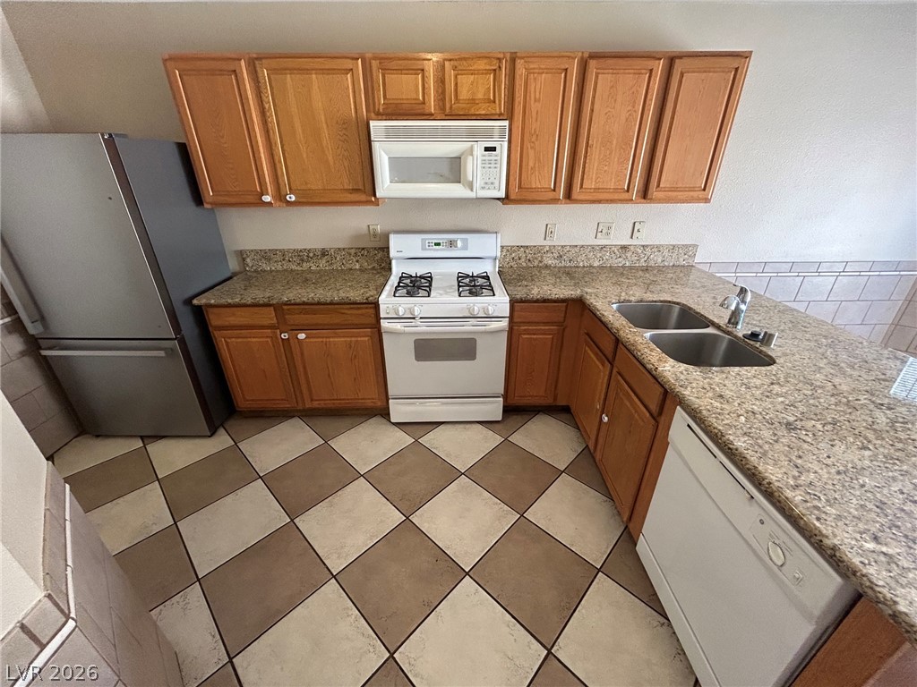 2806 Rungsted Street Las Vegas, NV 89142 - Photo 9 of 18 Functional kitchen with ample cabinet space, a gas range, and granite countertops.