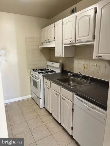 a kitchen with granite countertop white cabinets and appliances