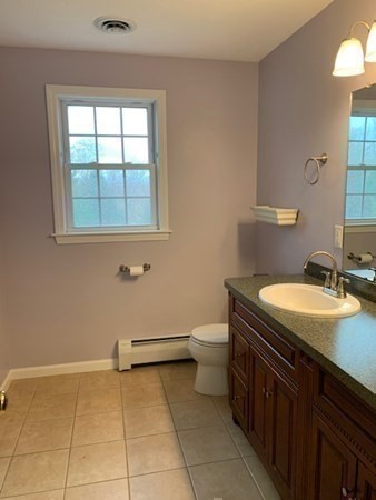 155 Barre Paxton Road Rutland, MA 01543 - Photo 32 of 42 a bathroom with a granite countertop sink a toilet and a window