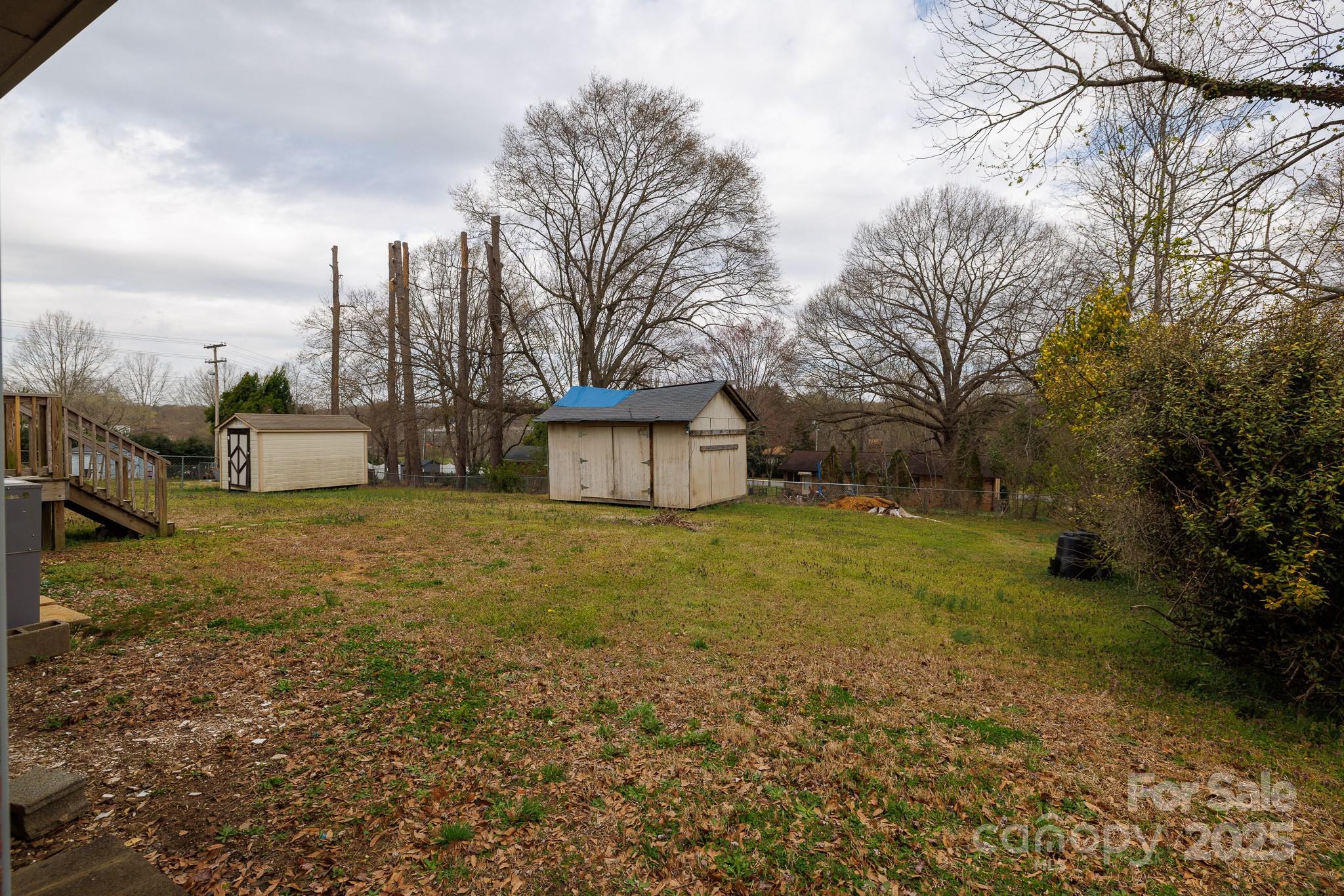 103 Perry Street Shelby, NC 28150 - Photo 18 of 22 a yellow house sitting in middle of forest