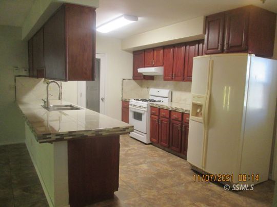 227 South Springside Street Ridgecrest, CA 93555 - Photo 5 of 22 a kitchen with stainless steel appliances a refrigerator and a stove