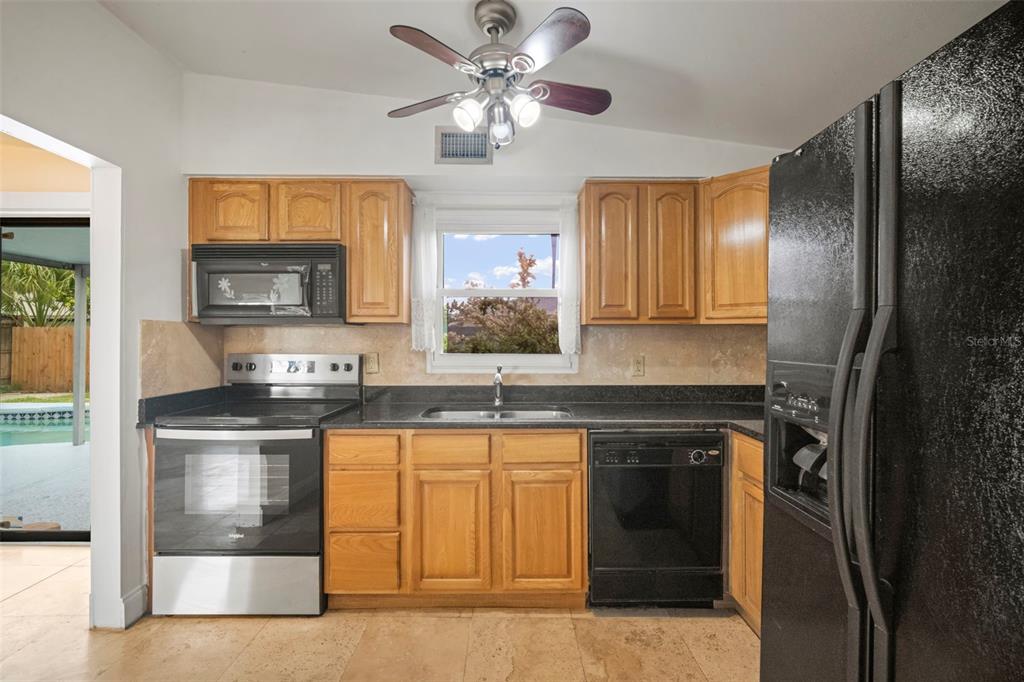 4712 Bessie Road Tampa, FL 33615 - Photo 14 of 28 a kitchen with stainless steel appliances granite countertop a stove and a sink