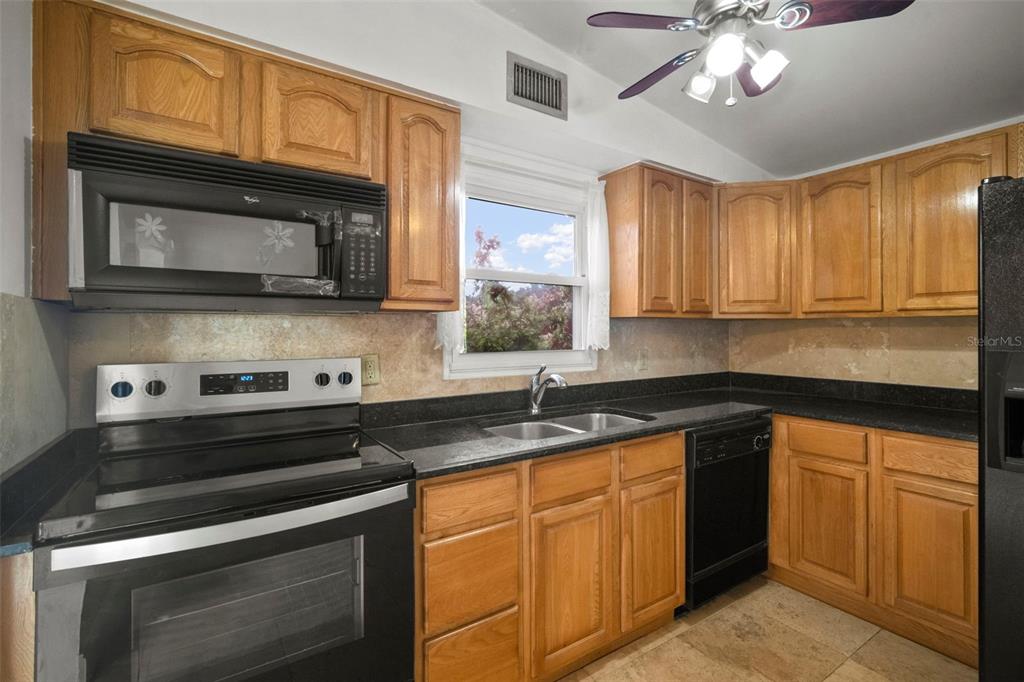 4712 Bessie Road Tampa, FL 33615 - Photo 15 of 28 a kitchen with granite countertop cabinets stainless steel appliances and a microwave