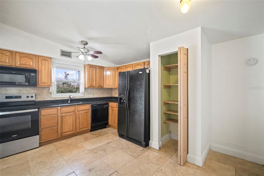 4712 Bessie Road Tampa, FL 33615 - Photo 17 of 28 a large kitchen with stainless steel appliances granite countertop a refrigerator and a sink