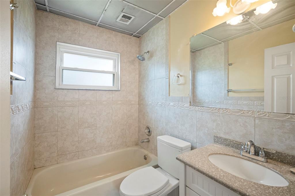 4712 Bessie Road Tampa, FL 33615 - Photo 22 of 28 a bathroom with a granite countertop sink toilet and shower