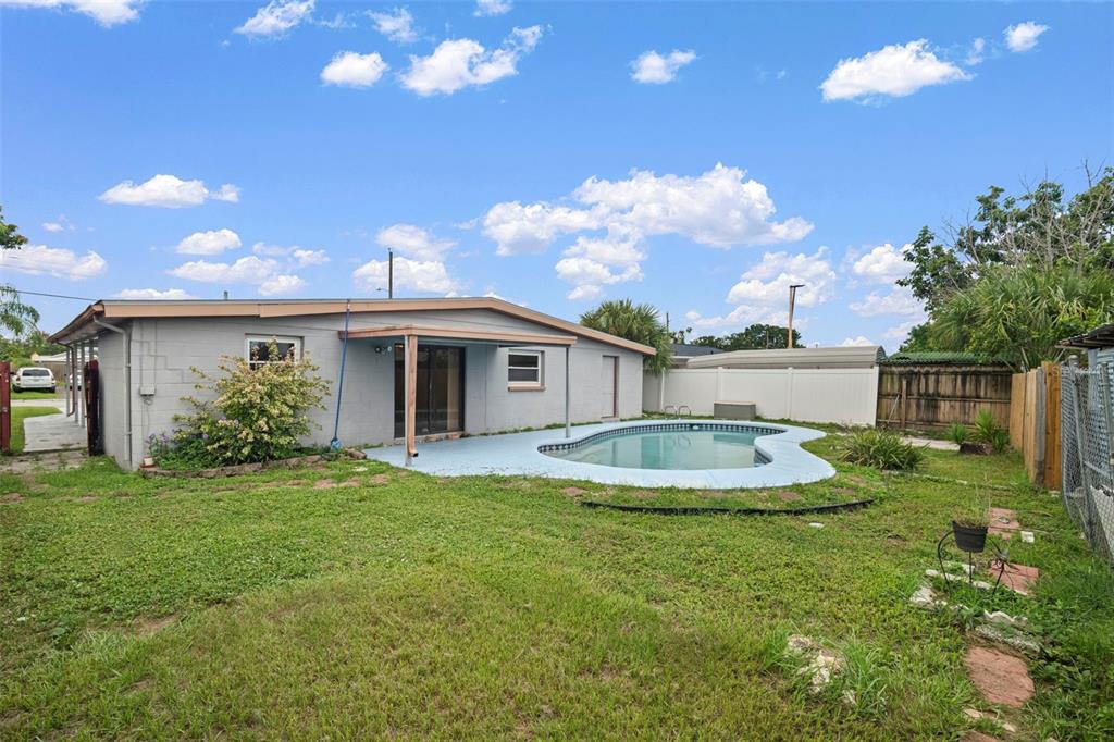 4712 Bessie Road Tampa, FL 33615 - Photo 4 of 28 a view of a house with a swimming pool and a yard