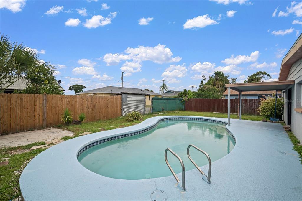4712 Bessie Road Tampa, FL 33615 - Photo 6 of 28 a swimming pool with outdoor seating and yard