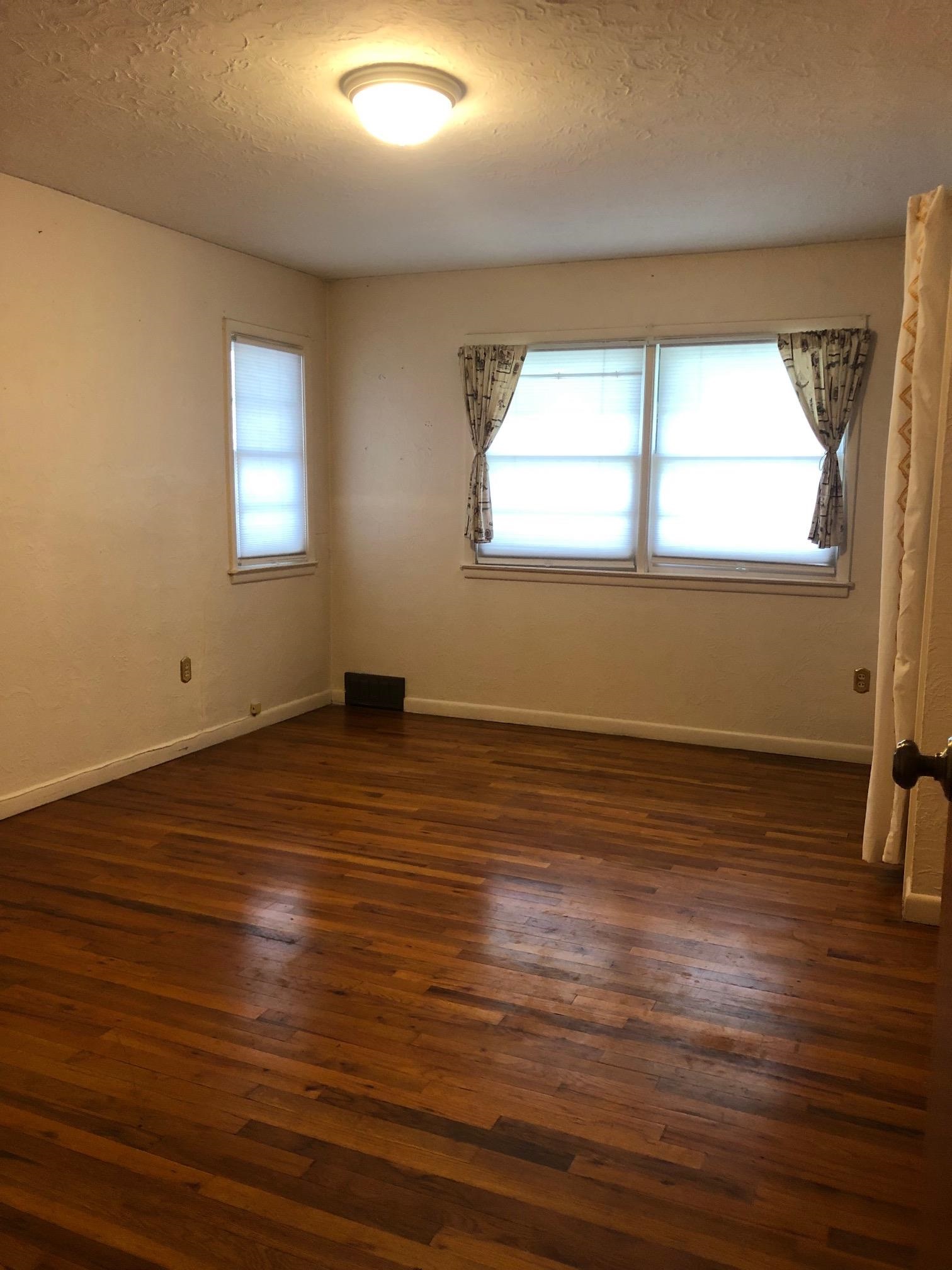 445 Hall Avenue Grand Junction, CO 81501 - Photo 16 of 23 an empty room with wooden floor and windows