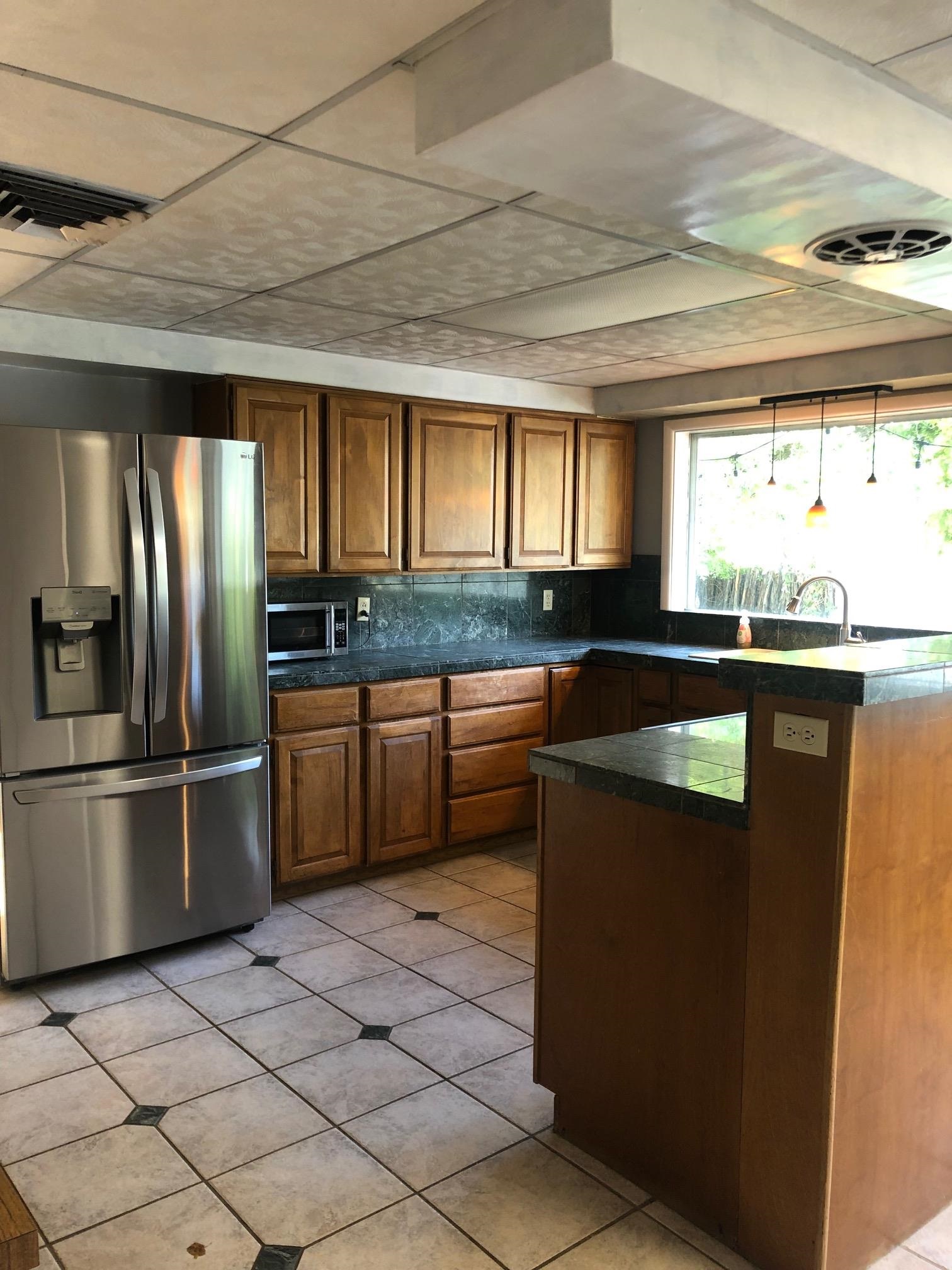 445 Hall Avenue Grand Junction, CO 81501 - Photo 4 of 23 a kitchen with granite countertop a sink stainless steel appliances and a window
