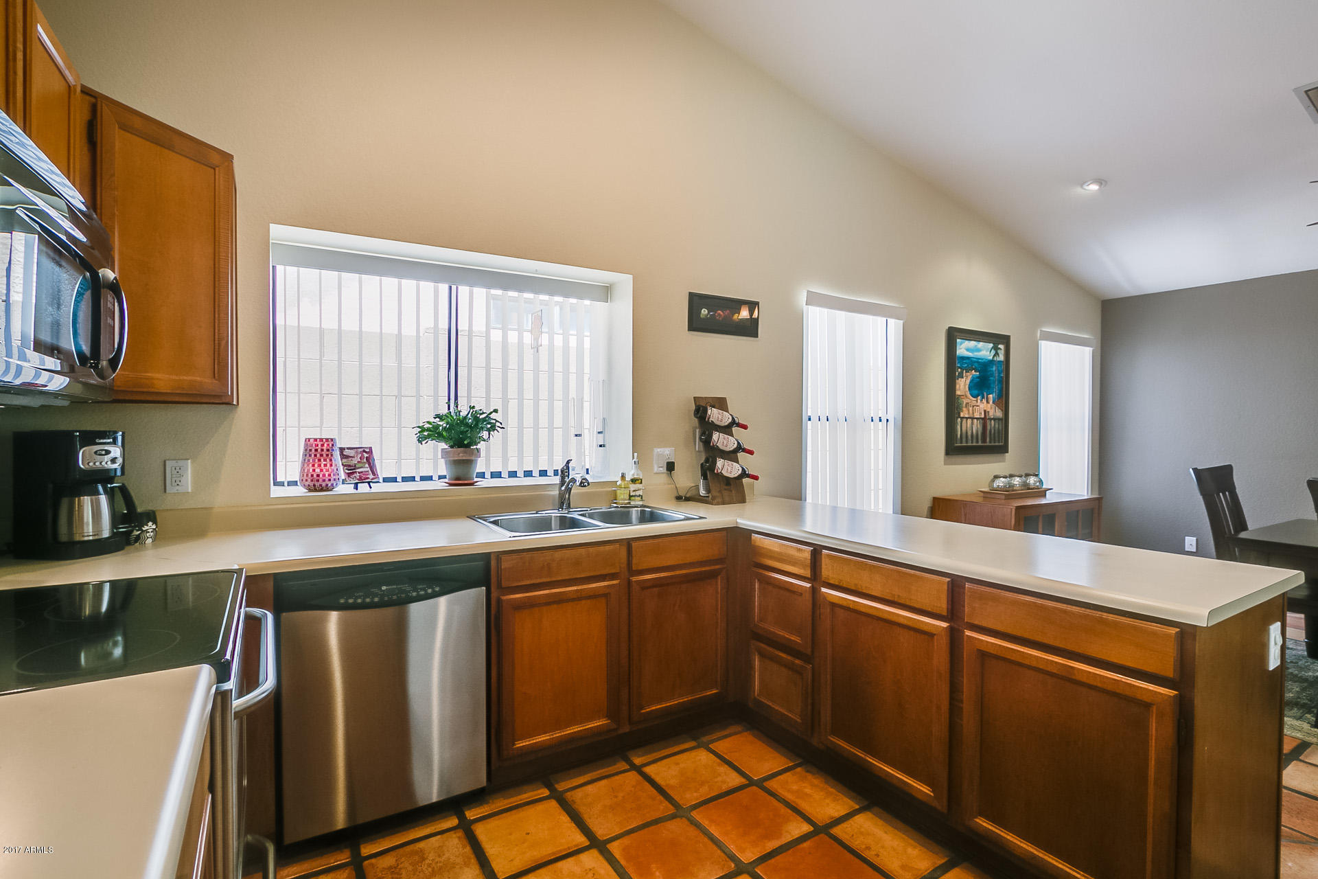 3623 East Agave Road Phoenix, AZ 85044 - Photo 14 of 41 a kitchen with stainless steel appliances granite countertop a sink and cabinets