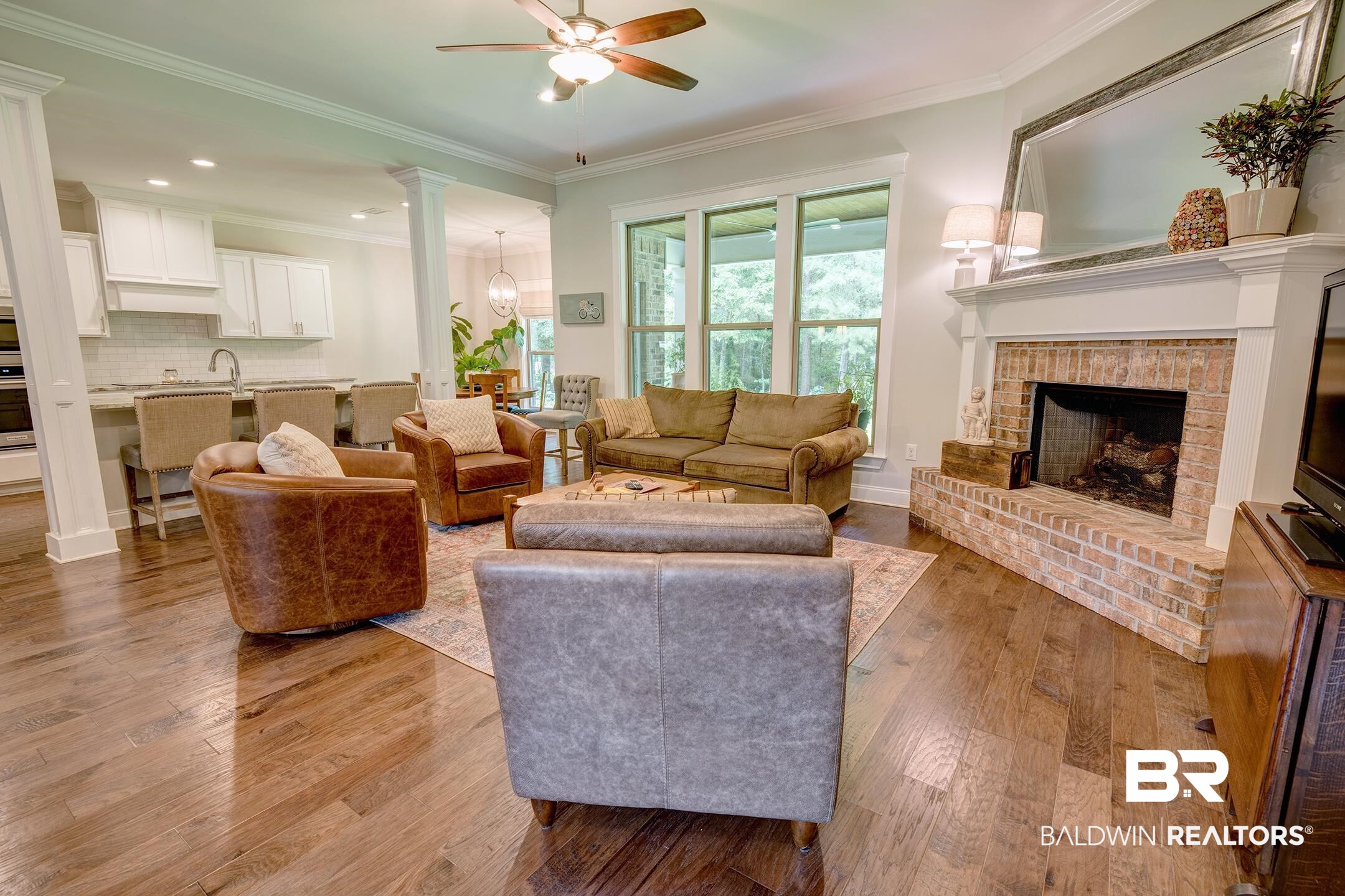 18754 Treasure Oaks Road Gulf Shores, AL 36542 - Photo 13 of 53 Living area with wood-finish flooring, a brick fireplace with a white mantel, and a ceiling fan