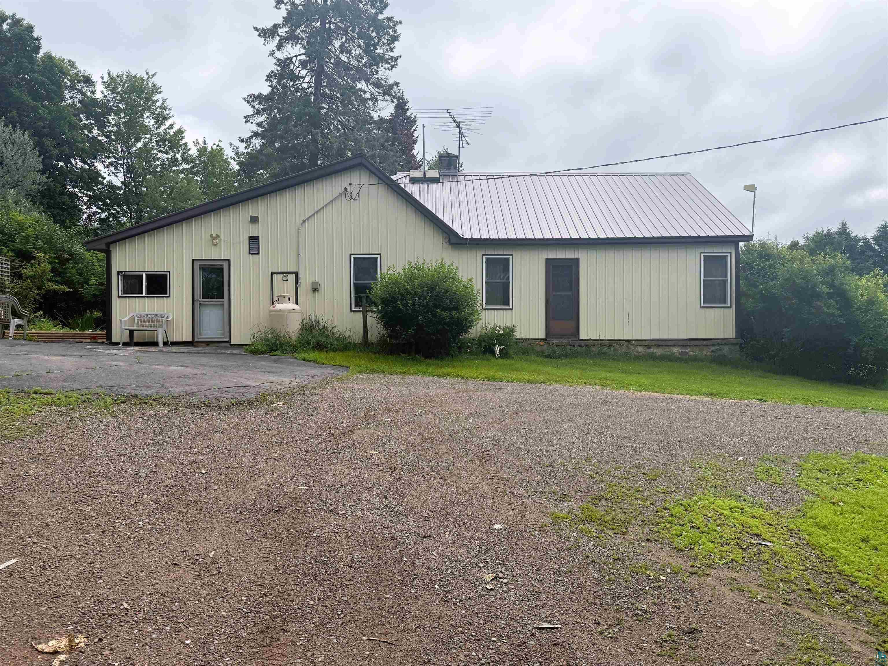 3541 Bent Trout Lake Road Barnum, MN 55707 - Photo 1 of 41 Single-story residence featuring vertical siding, a metal roof, and a gravel driveway