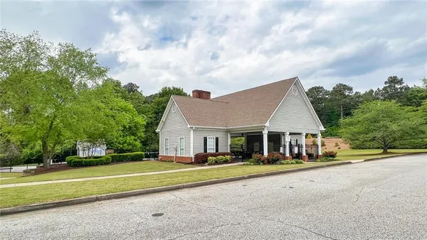 a view of a house with a big yard and large trees