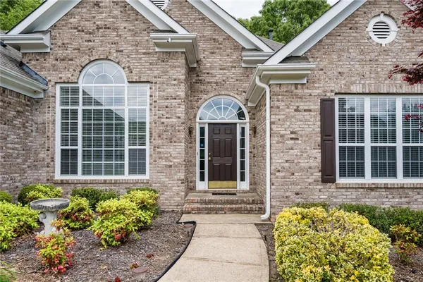 a front view of a house with a garden