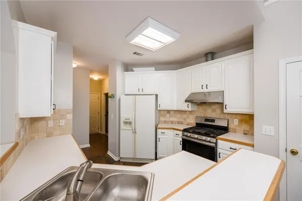 a kitchen with stainless steel appliances a refrigerator sink and stove