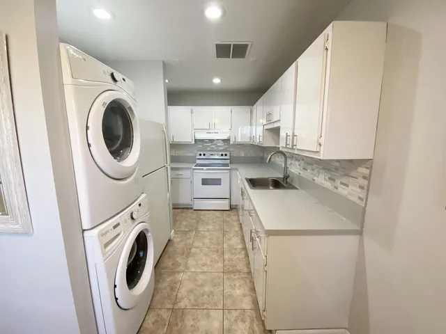 a kitchen with white cabinets and stainless steel appliances