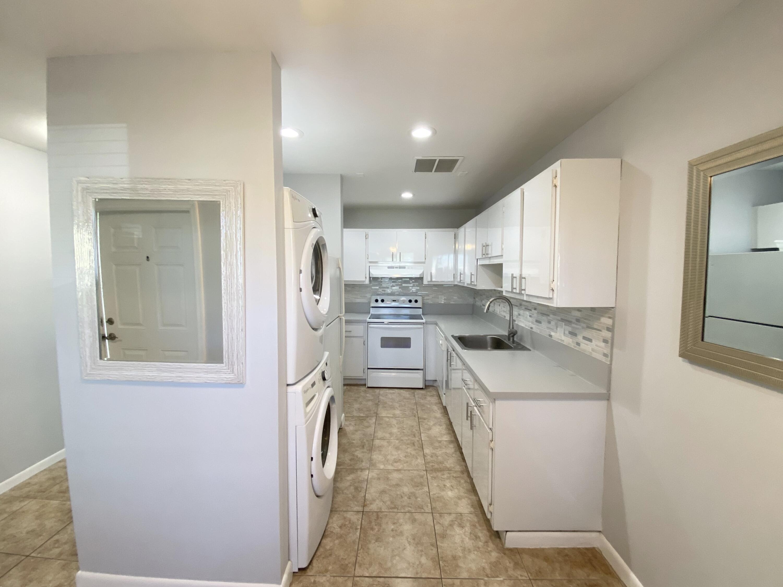1100 Boxwood Drive, Unit 101 Delray Beach, FL 33445 - Photo 22 of 33 a kitchen with white cabinets and stainless steel appliances