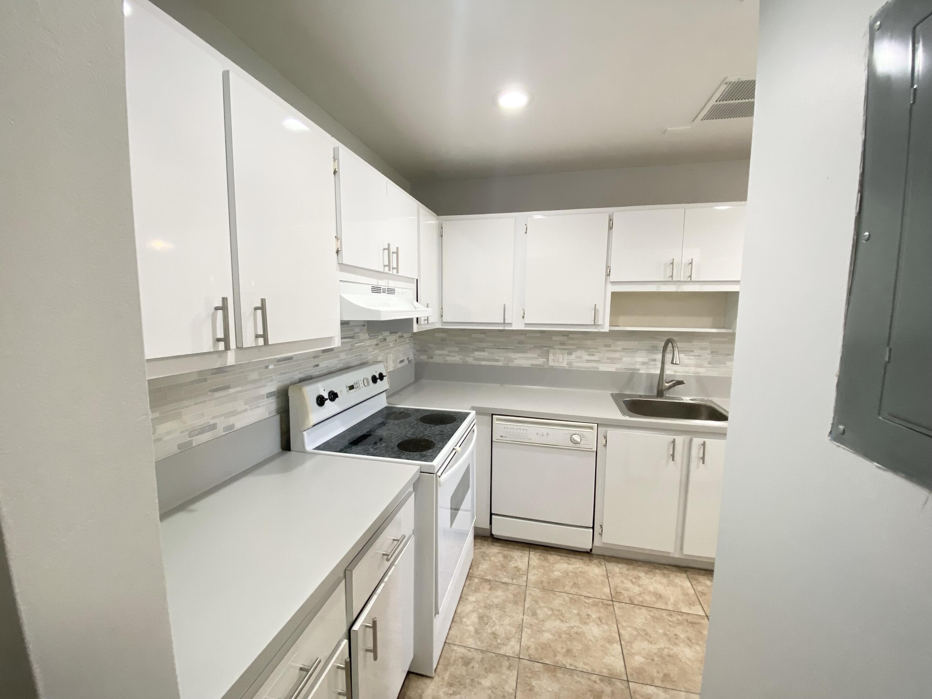 1100 Boxwood Drive, Unit 101 Delray Beach, FL 33445 - Photo 23 of 33 a kitchen with a sink a stove and cabinets