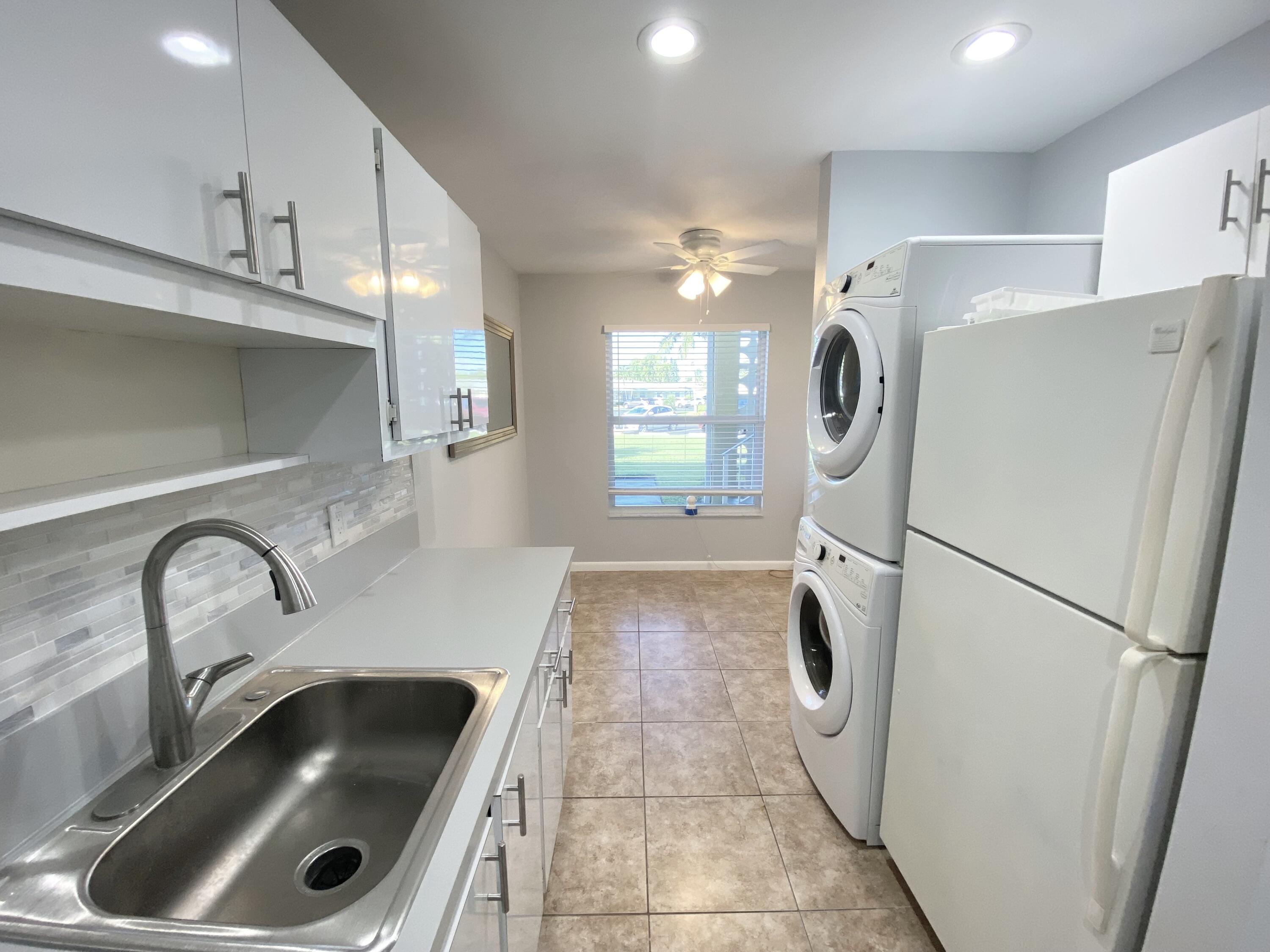 1100 Boxwood Drive, Unit 101 Delray Beach, FL 33445 - Photo 4 of 33 a kitchen with refrigerator and car