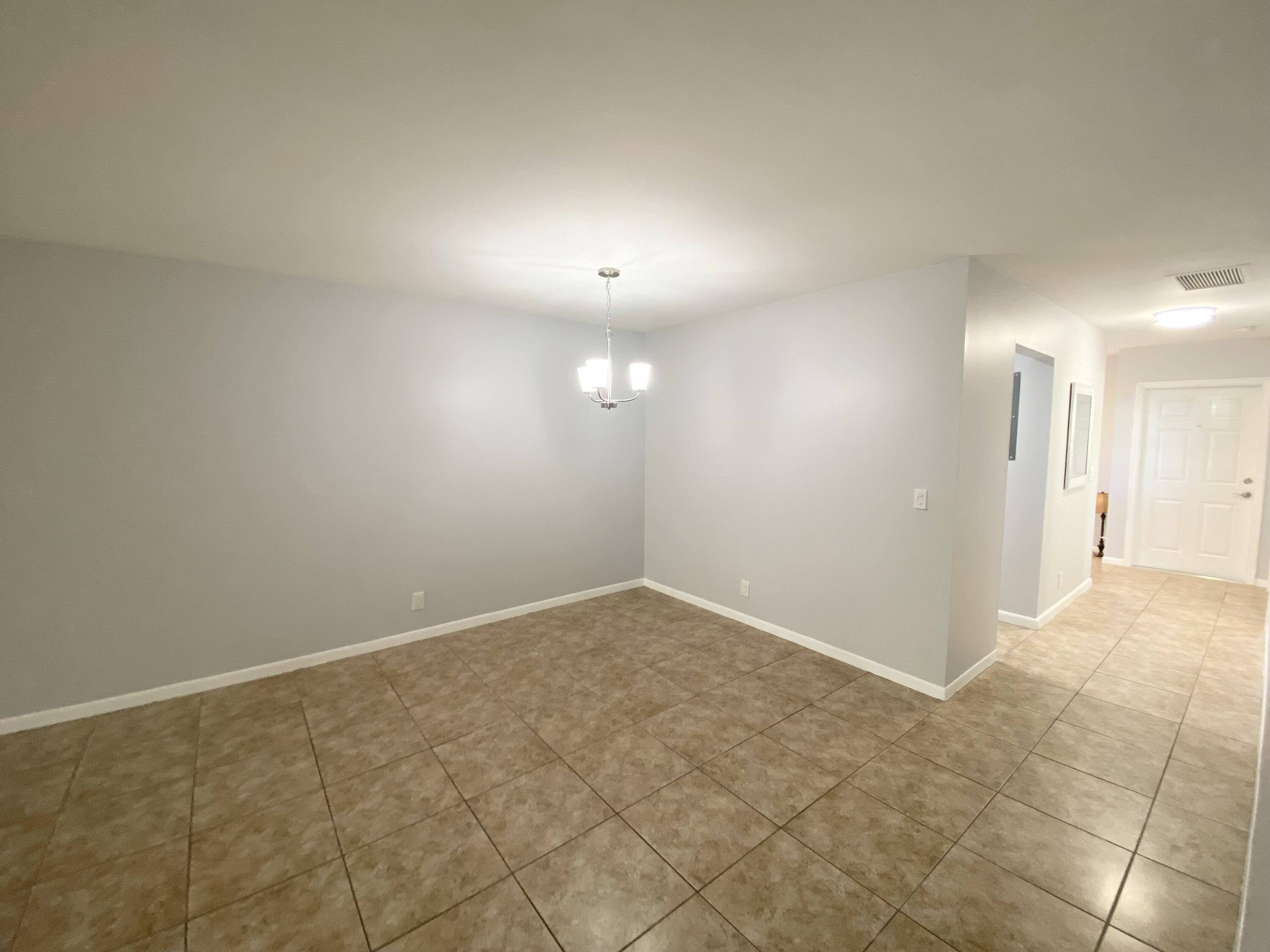 1100 Boxwood Drive, Unit 101 Delray Beach, FL 33445 - Photo 9 of 33 an empty room with fan and entrance