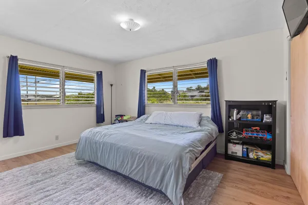 a bedroom with a bed and a dresser next to a window