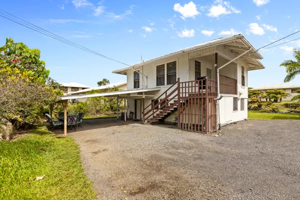 a view of a house with a patio and a yard