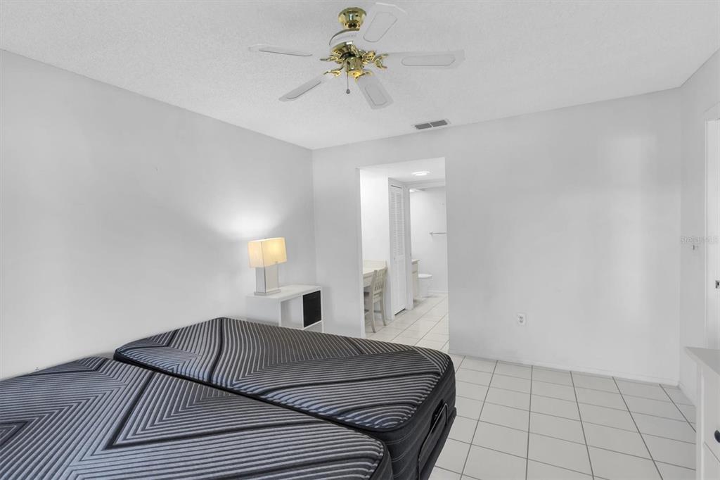 11410 Carriage Hill Drive, Unit 1 Port Richey, FL 34668 - Photo 14 of 63 a bed room with a bed and a chandelier