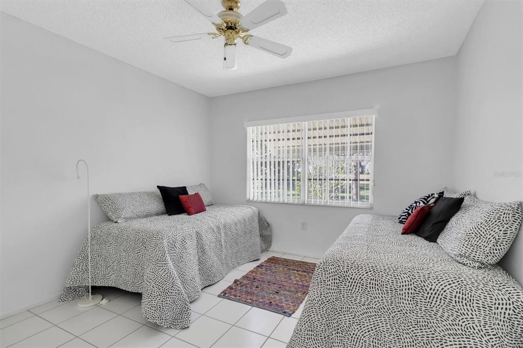 11410 Carriage Hill Drive, Unit 1 Port Richey, FL 34668 - Photo 18 of 63 a bedroom with a bed and a window