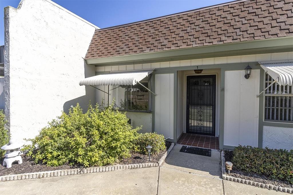 11410 Carriage Hill Drive, Unit 1 Port Richey, FL 34668 - Photo 31 of 63 a front view of a house with a yard