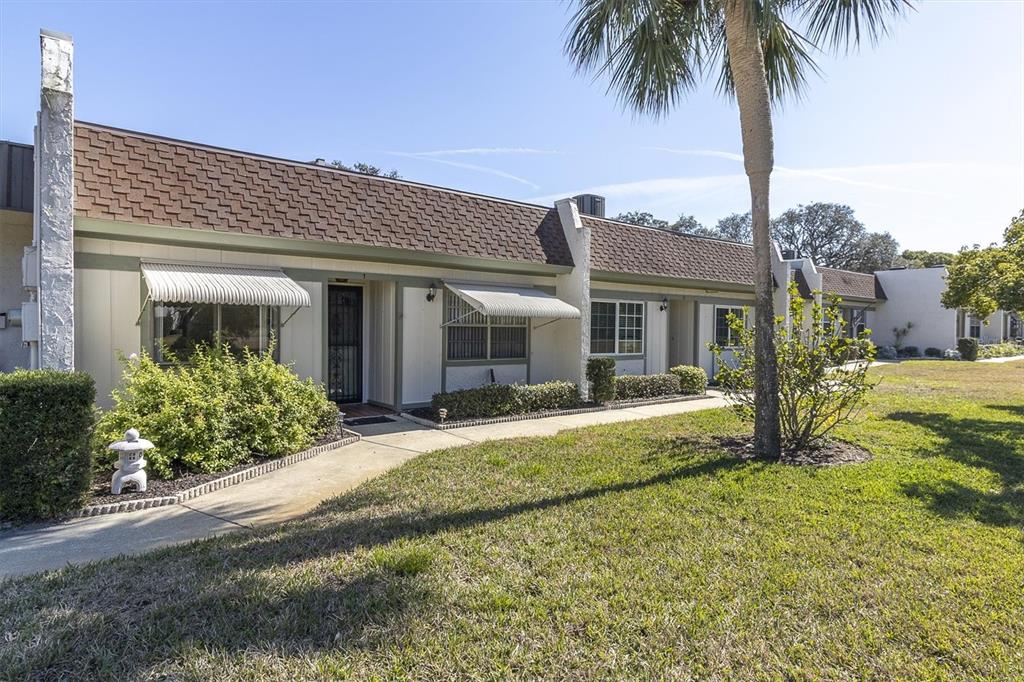 11410 Carriage Hill Drive, Unit 1 Port Richey, FL 34668 - Photo 33 of 63 front view of a house with a yard