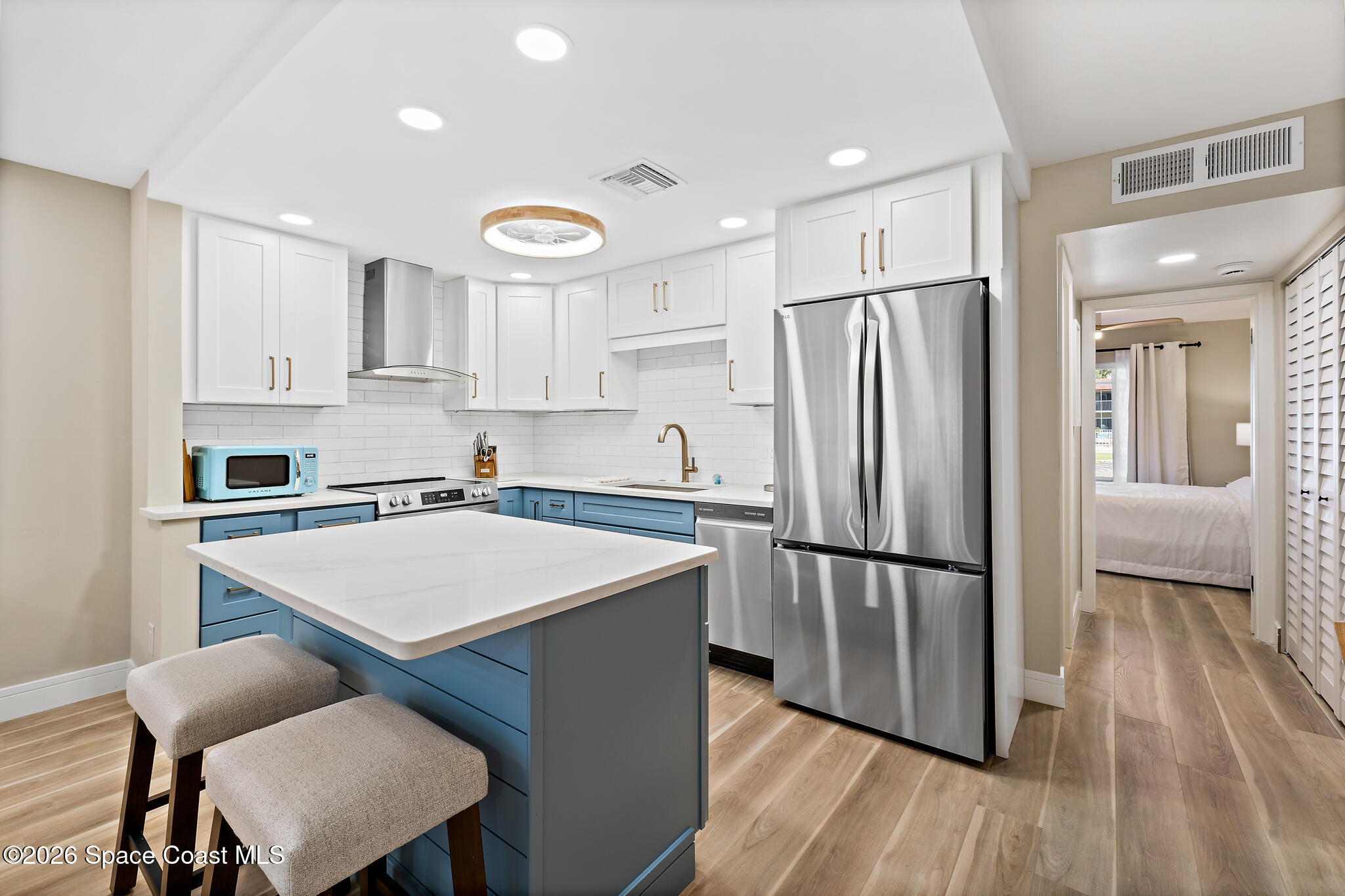 150 Intrepid Way, Unit 8D Cape Canaveral, FL 32920 - Photo 13 of 36 a kitchen with stainless steel appliances refrigerator wooden floor dining table and chairs