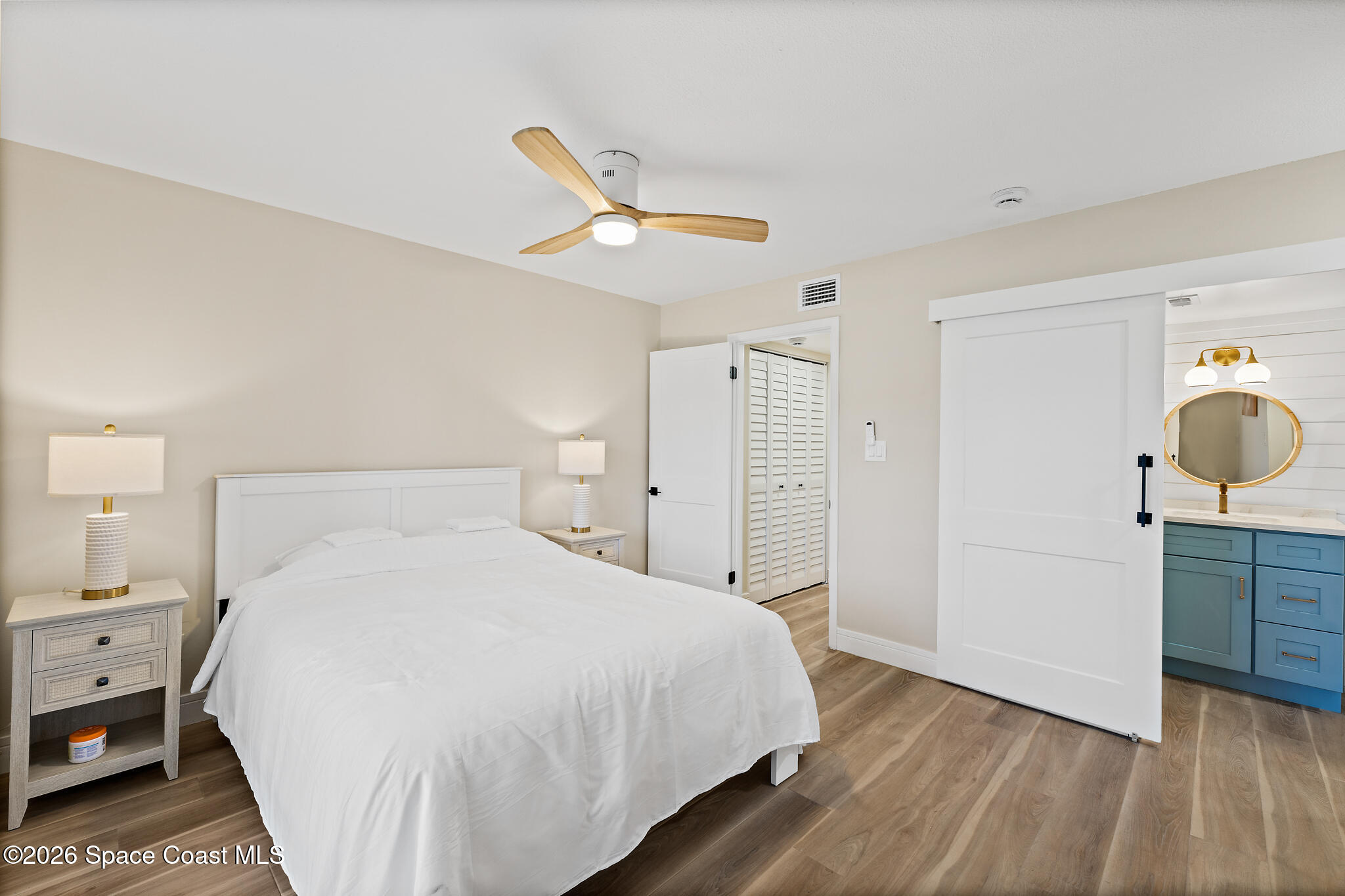 150 Intrepid Way, Unit 8D Cape Canaveral, FL 32920 - Photo 17 of 36 a bedroom with a bed and wooden floor
