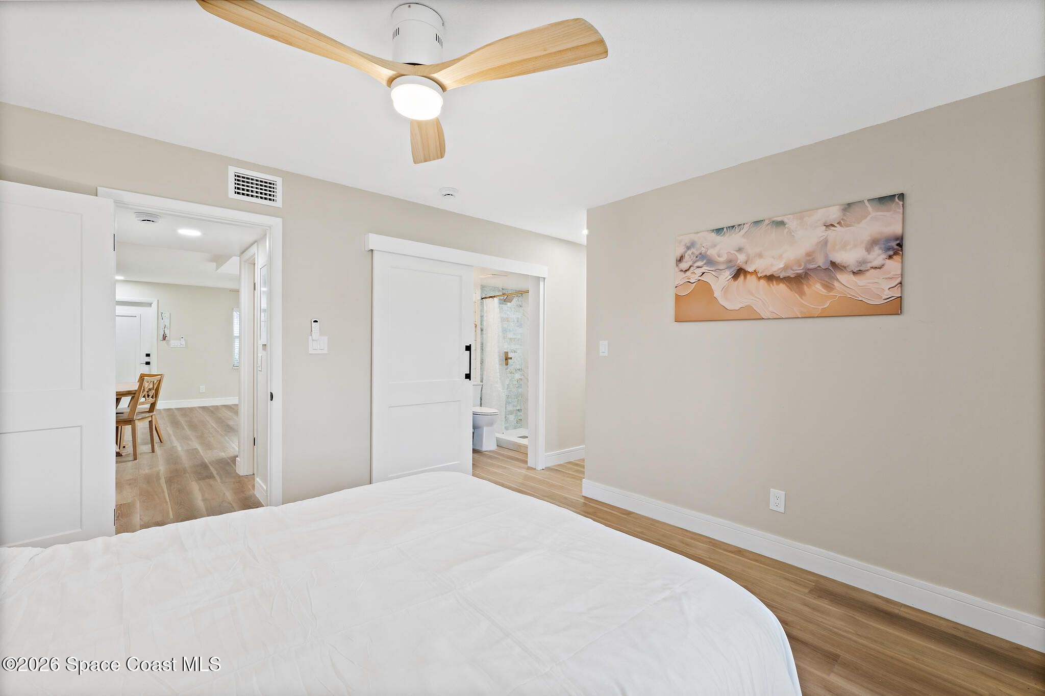 150 Intrepid Way, Unit 8D Cape Canaveral, FL 32920 - Photo 18 of 36 a bedroom with a bed and a chandelier