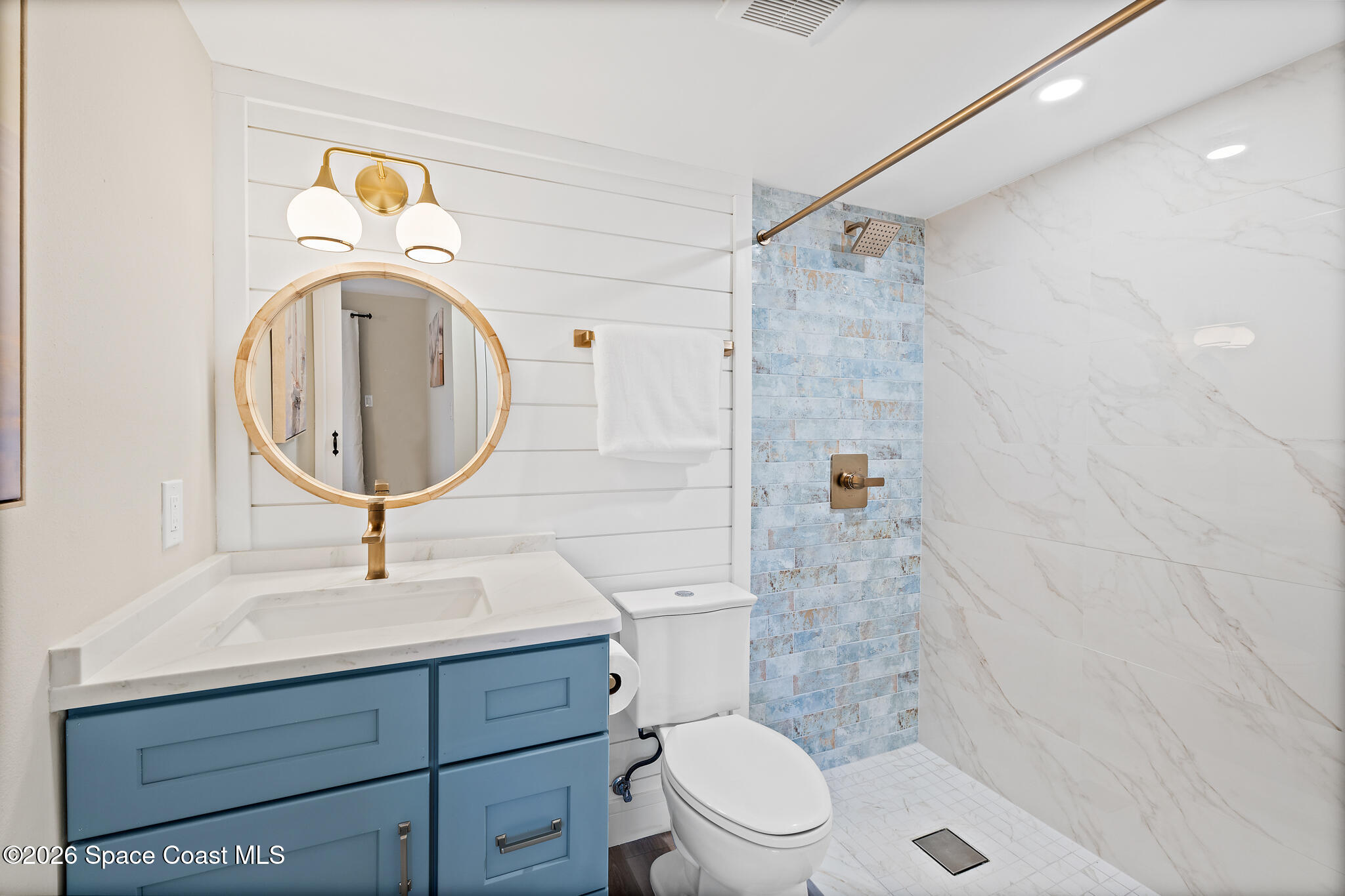 150 Intrepid Way, Unit 8D Cape Canaveral, FL 32920 - Photo 19 of 36 a bathroom with a sink a mirror a toilet and shower