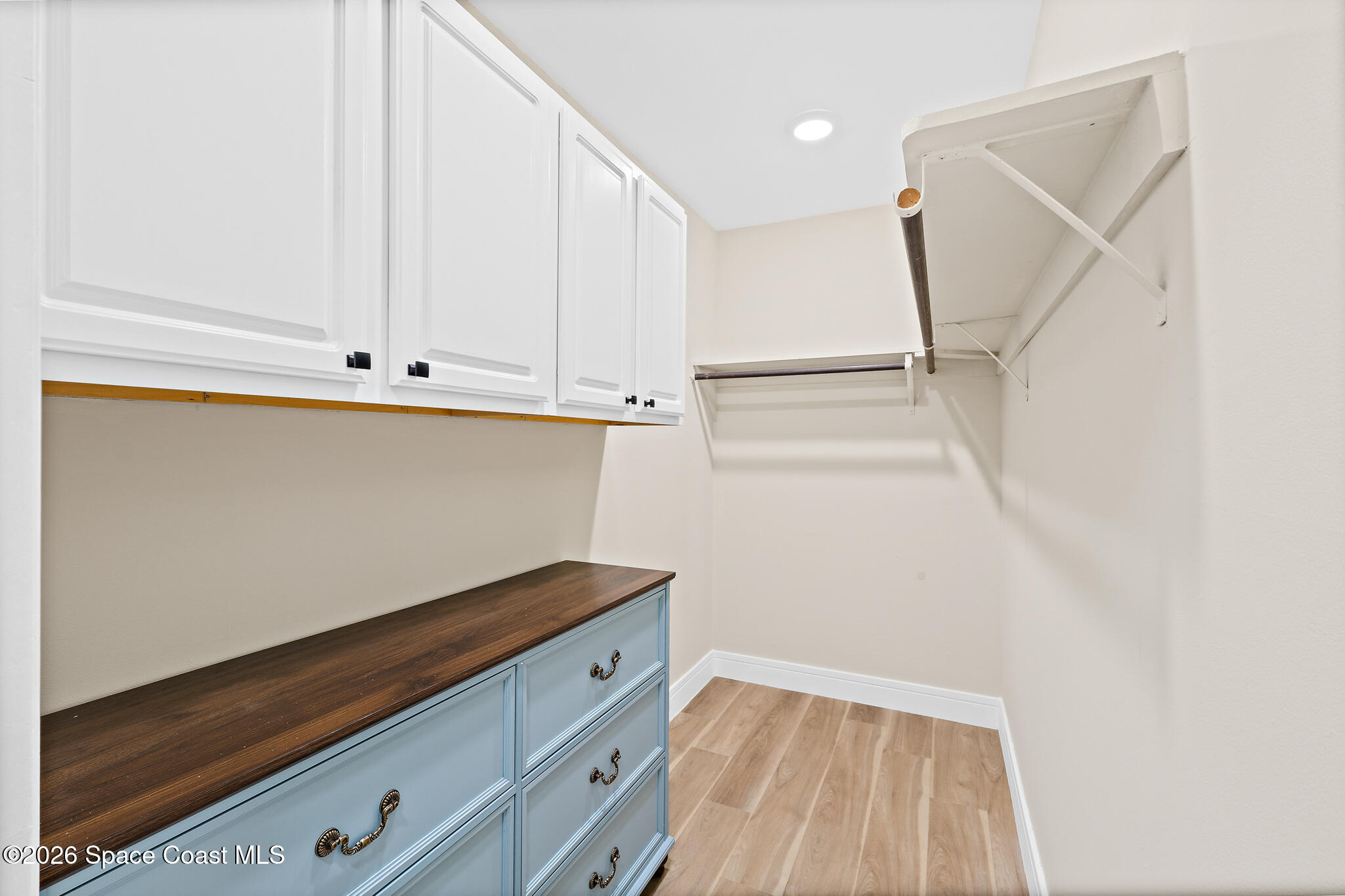 150 Intrepid Way, Unit 8D Cape Canaveral, FL 32920 - Photo 22 of 36 a view of an empty room with wooden floor and cabinets