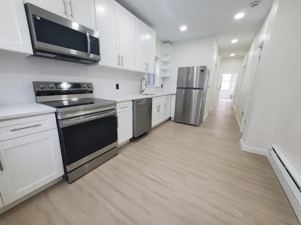 a kitchen with stainless steel appliances granite countertop a stove a refrigerator and a microwave