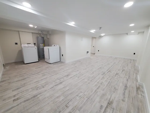 a view of a big room with wooden floor and windows