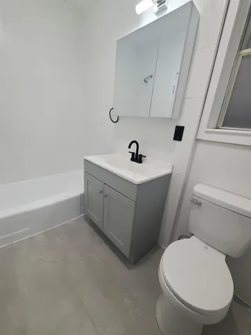 a white toilet sitting next to a bathroom sink