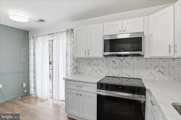 a kitchen with cabinets stainless steel appliances and a counter space