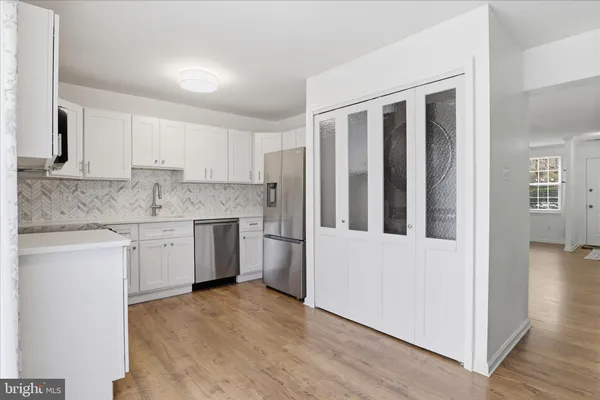 a kitchen with granite countertop white cabinets and white appliances