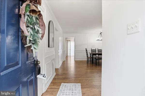 a view of a hallway with wooden floor and a potted plant