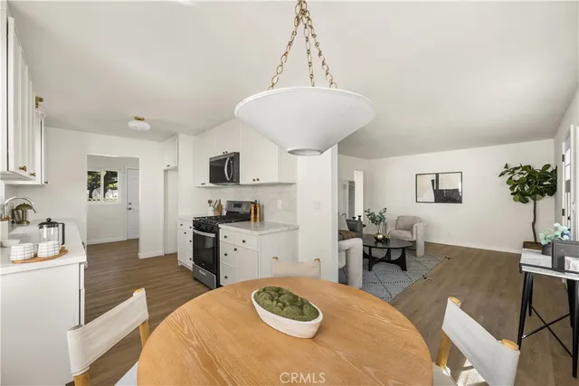 a living room with stainless steel appliances kitchen island furniture and a table