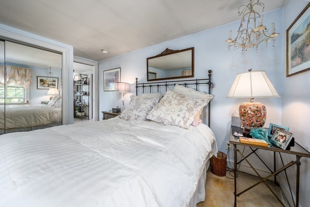 41 Aunt Debby's Road Dennis Port, MA 02639 - Photo 29 of 42 a spacious bedroom with a bed and a chandelier